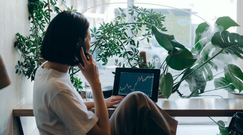 Businesswoman in White Shirt Sitting on Chair while Having Phone Call