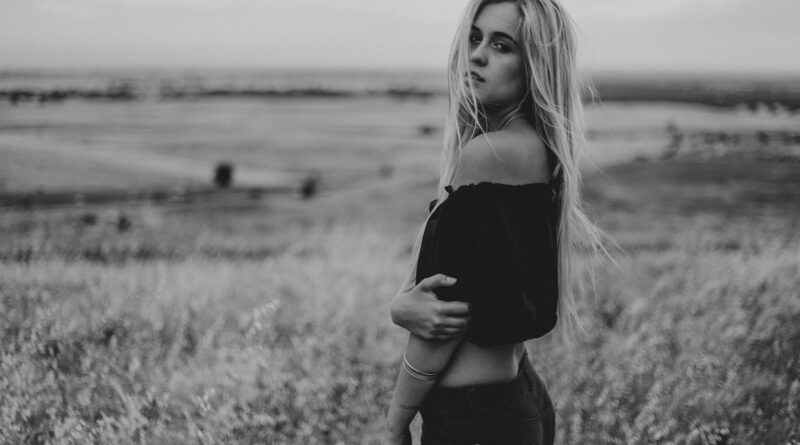 woman in black off-shoulder crop-top standing on grass field