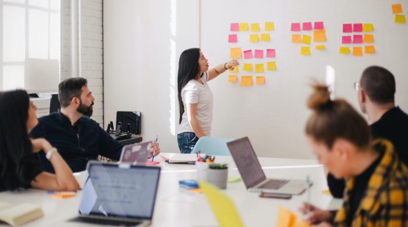 woman placing sticky notes on wall